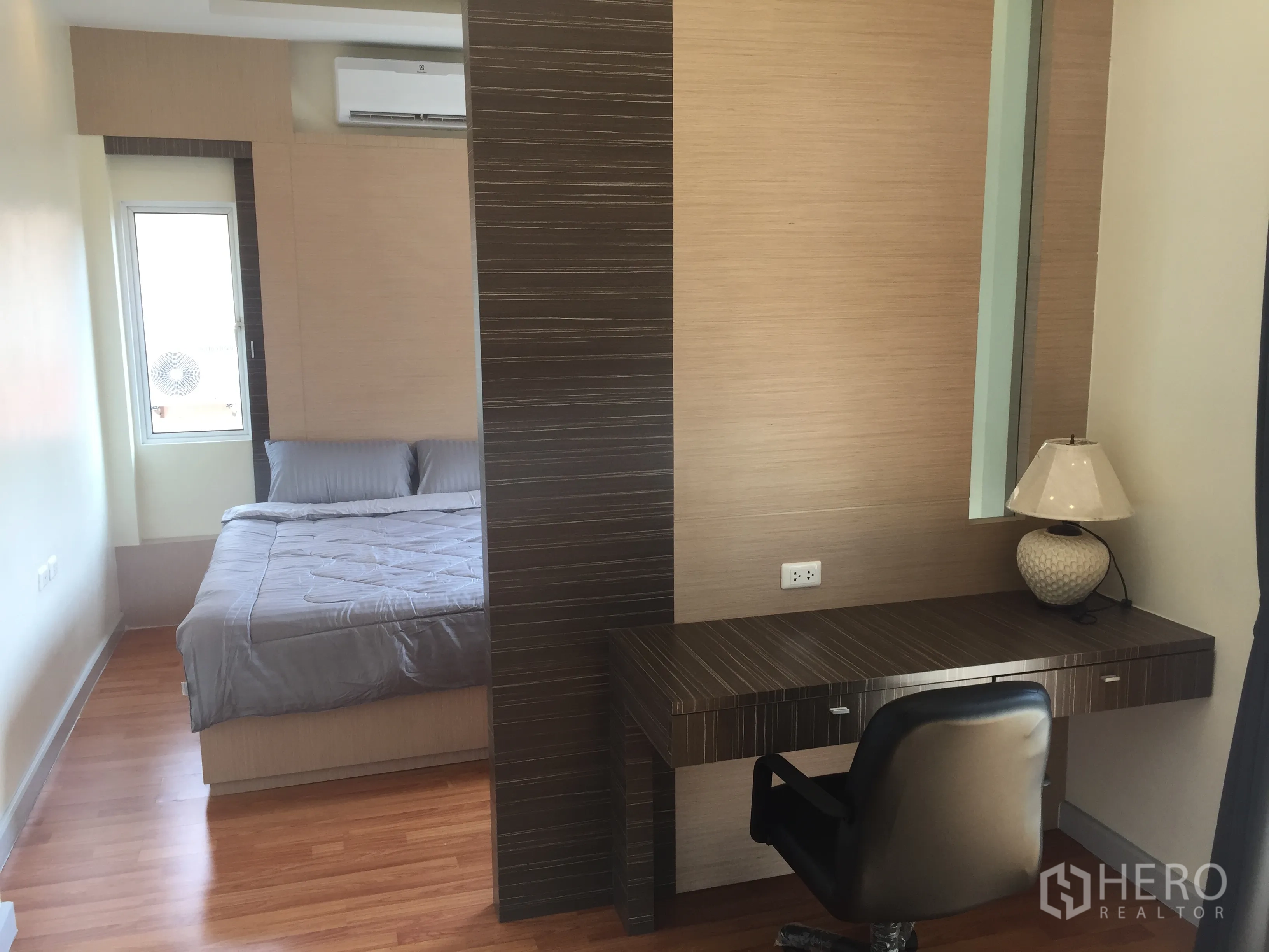 Detached House for sale in Lat Krabang, Bangkok - Master bedroom with wood floors, built-in desk and air conditioner.