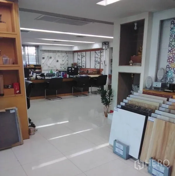 带办公室的家 出租在Min Buri, Bangkok - 明亮的开放式办公区，带瓷砖样品展示与内置置物架和座位区。