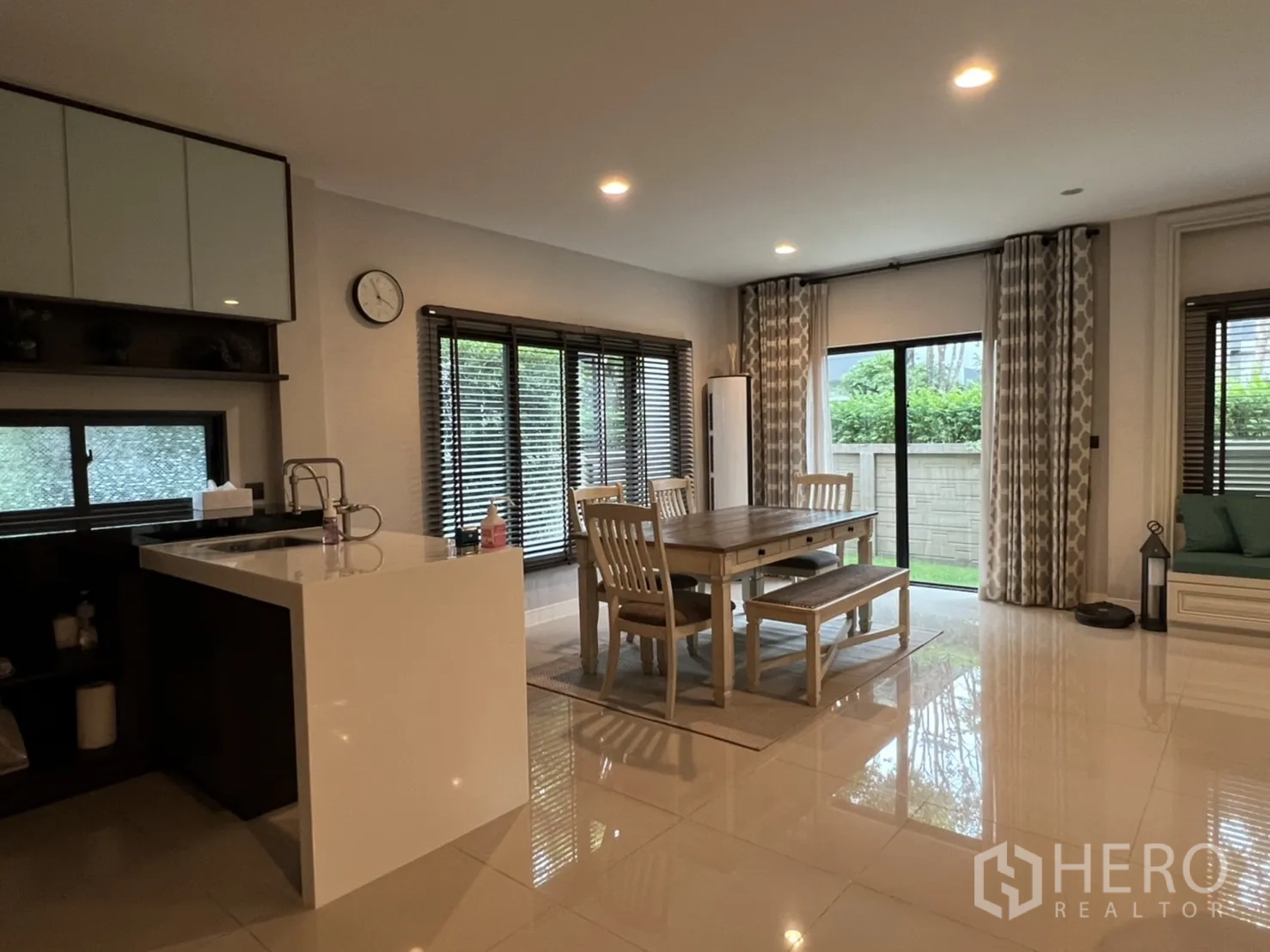 Detached House for rent or sale in Bang Kapi, Bangkok - Dining area beside sliding doors and a compact pantry with a white island counter.