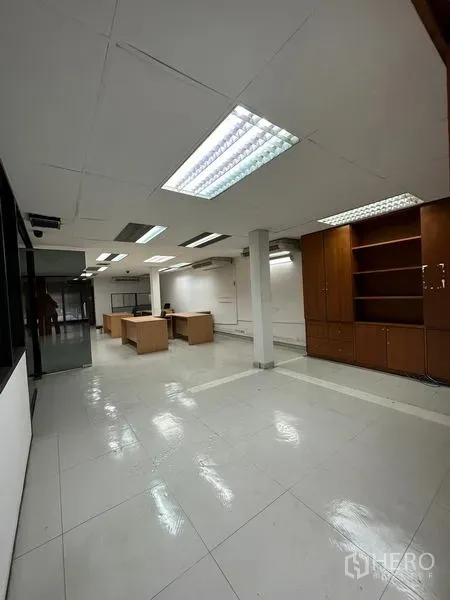 Office Space for rent in Pathum Wan, Bangkok - Bright work area with white tiles, built-in wooden cabinets and desks.