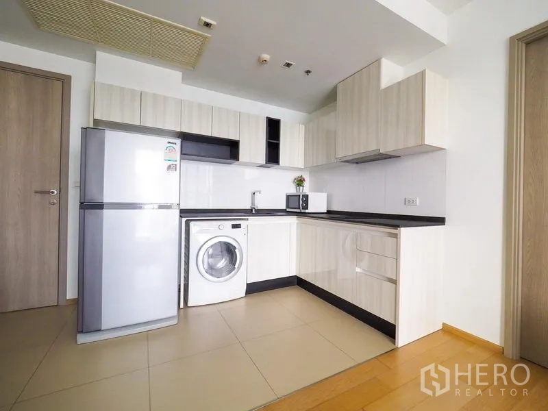 公寓 出租在Watthana, Bangkok - U形现代厨房，配冰箱、洗衣机、微波炉与充足橱柜。