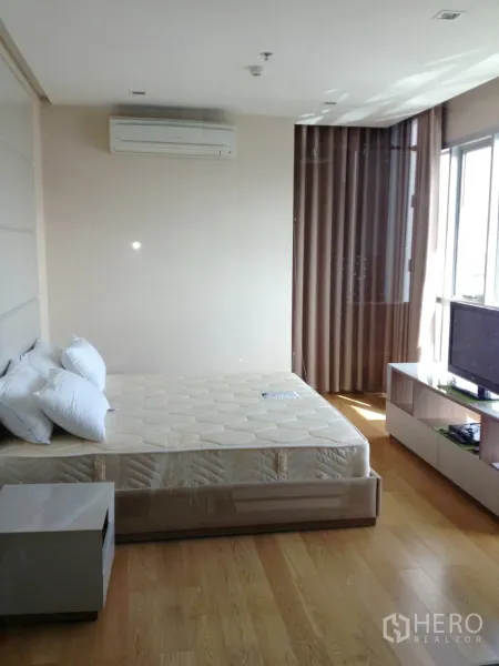 公寓 出租在Ratchathewi, Bangkok - 宽敞主卧配大床、电视柜、空调与落地窗帘。