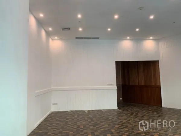 Retail Space for rent in Khlong Toei, Bangkok - Open retail area with high ceiling, spotlights and a wooden feature wall.
