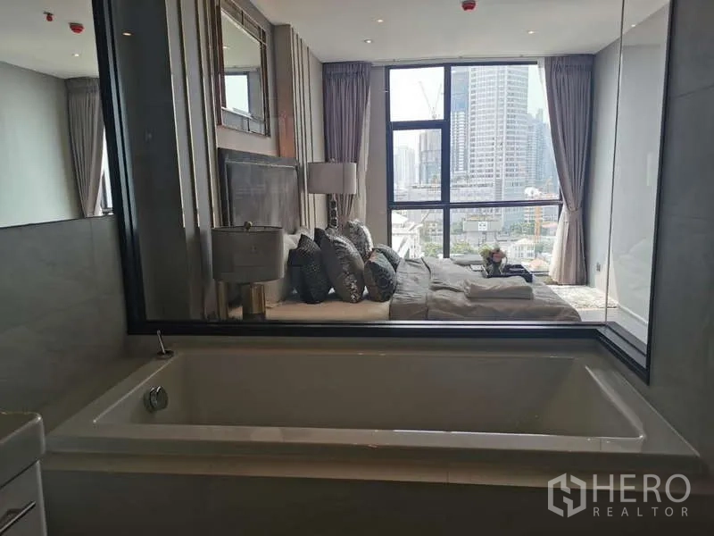 公寓 出租或出售在Watthana, Bangkok - 套内浴室浴缸，透窗可见卧室与城市景色