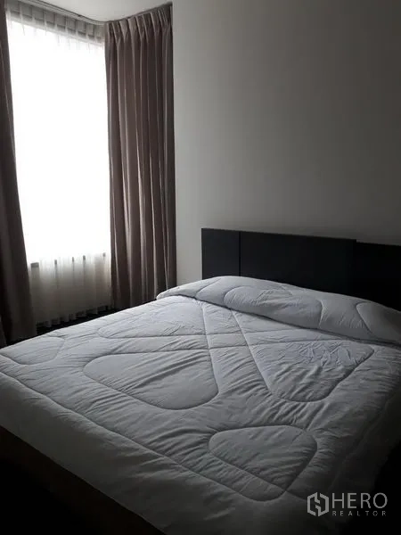 公寓 出租或出售在Watthana, Bangkok - 现代公寓卧室，双人床与软包床头，大窗配窗帘，氛围温馨。