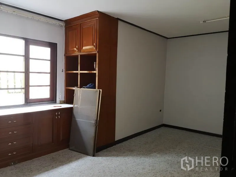 Detached House for sale - Bright room with a large window and built-in wooden cabinets and shelving.