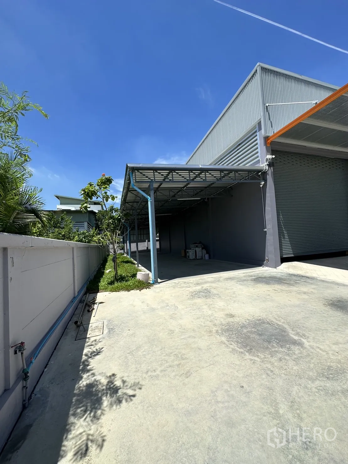 工厂 出售在Lam Luk Ka, Pathum Thani - 建筑侧院带雨棚作业区与绿化带。