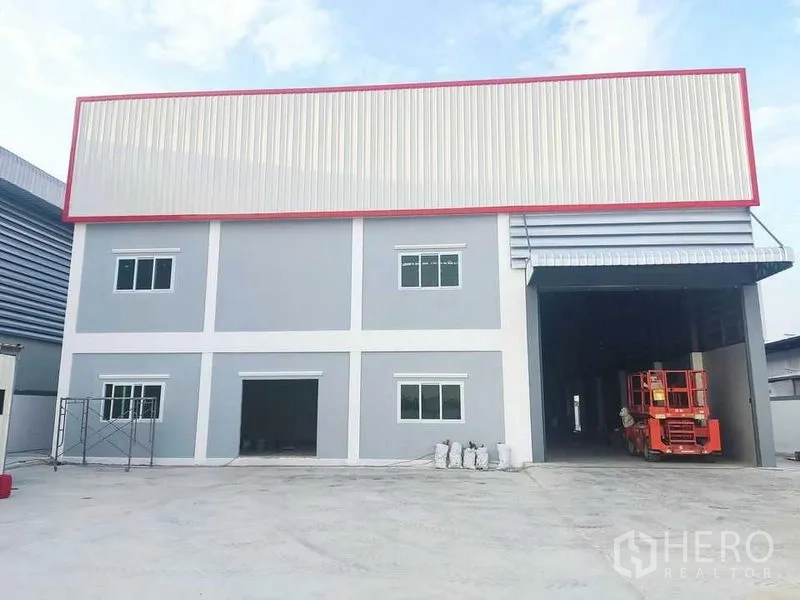 โรงงาน ขายในKrathum Baen, Samut Sakhon - อาคารโรงงานสองชั้นพร้อมประตูม้วนขนาดใหญ่ พื้นที่จอดและลานโหลดคอนกรีต