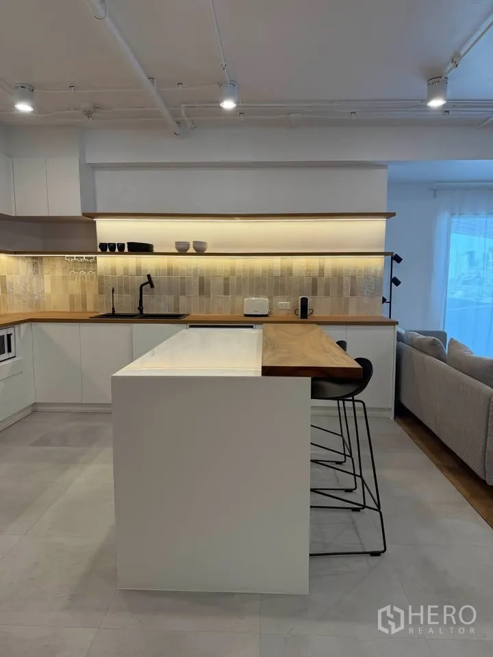 公寓 for rent in Watthana, Bangkok - 厨房岛台与吧椅，整面瓷砖挡板一览无遗。