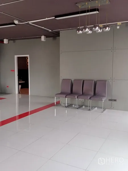 办公空间 出租在Khlong Toei, Bangkok - 极简灰色墙面，四把椅子与金属球形吊灯，旁有内侧门口。