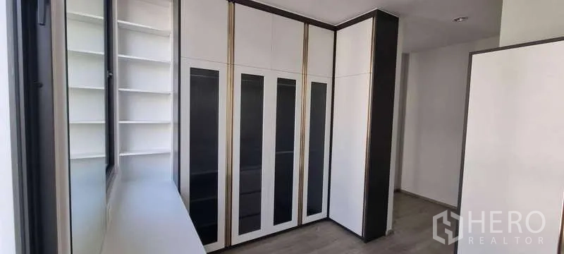 独立式住宅 出租在Lat Krabang, Bangkok - 整墙衣柜与开放置物架的衣帽间，采光充足。
