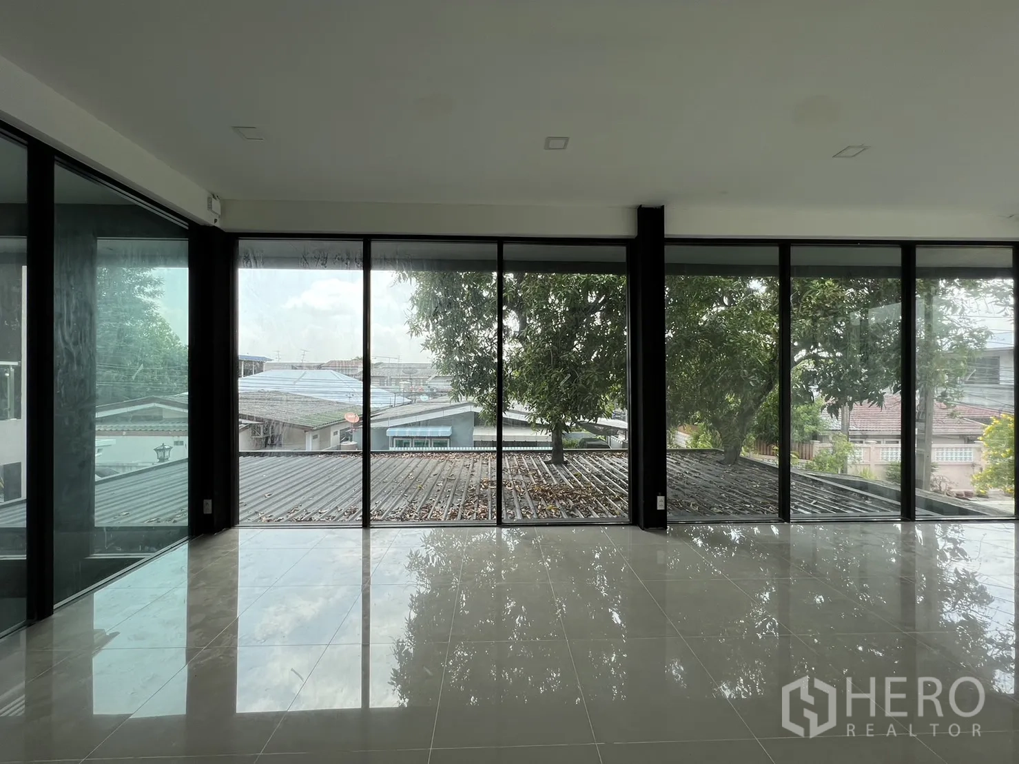 Detached House for rent or sale in Phra Khanong, Bangkok - Upper living space with wall-to-wall windows and treetop views.
