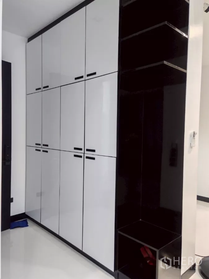 Detached House for rent in Wang Thonglang, Bangkok - Tall built-in white cabinets with contrasting black open shelving.