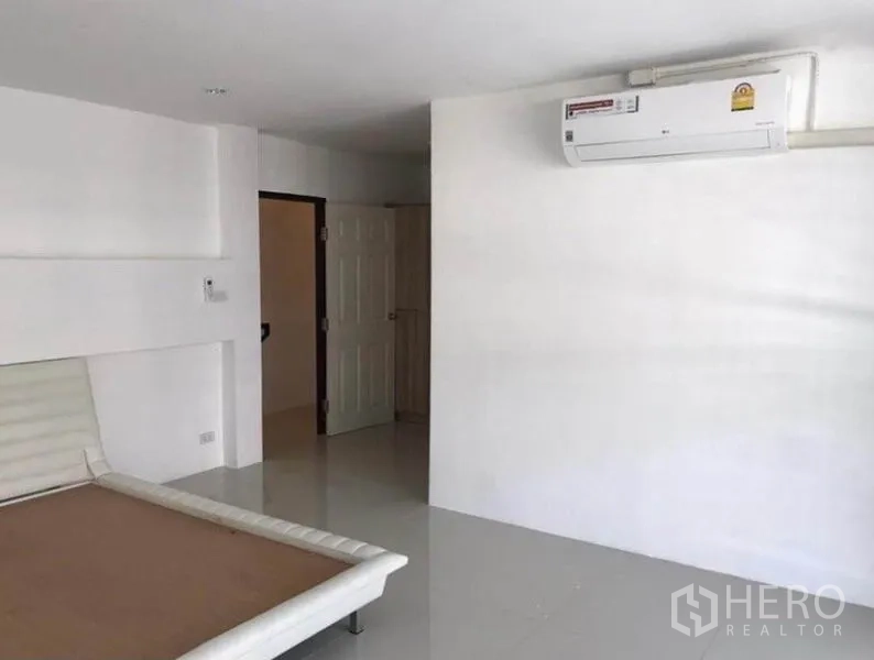 联排别墅 出租在Wang Thonglang, Bangkok - 大卧室，白墙、空调与内置床架。
