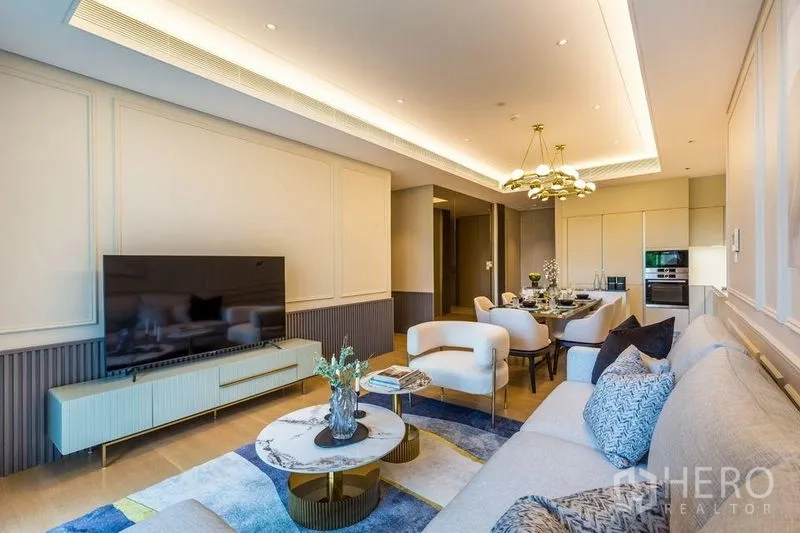 Condominium for rent in Pathum Wan, Bangkok - Contemporary living area with TV console, sofa set, and dining zone in warm tones.