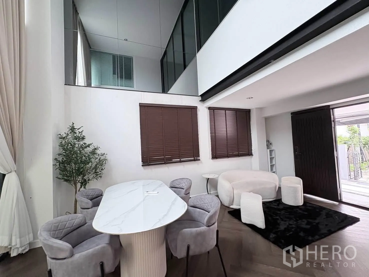 独栋房屋 for rent in Saphan Sung, Bangkok - 挑高客餐厅，配大理石面餐桌、软包餐椅与百叶窗。