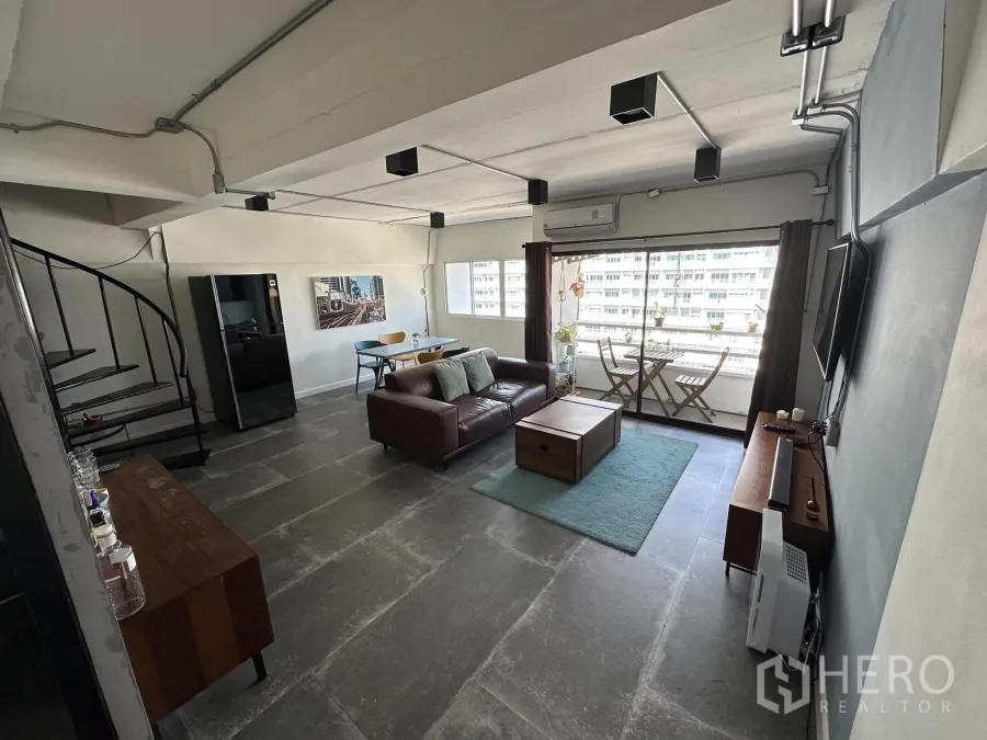 公寓 出租在Watthana, Bangkok - 客厅设有旋转楼梯、大窗与带座位的阳台。