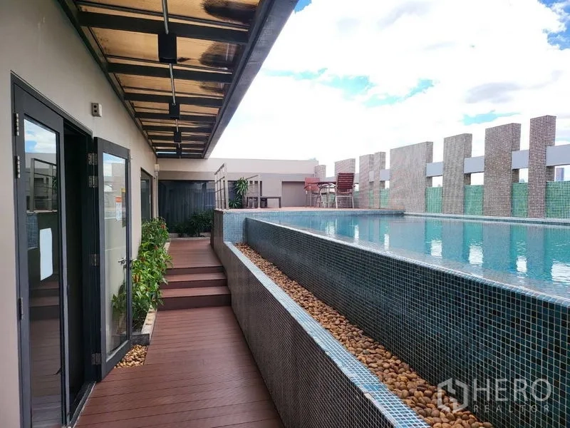 Condominium for rent or sale in Phaya Thai, Bangkok - Rooftop swimming pool with deck seating and a covered walkway.