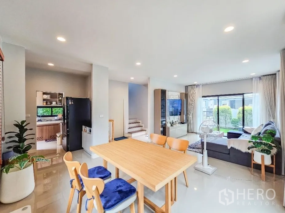 Detached House for sale in Lam Luk Ka, Pathum Thani - Spacious open-plan living and dining area with stairway and sliding doors to the garden.