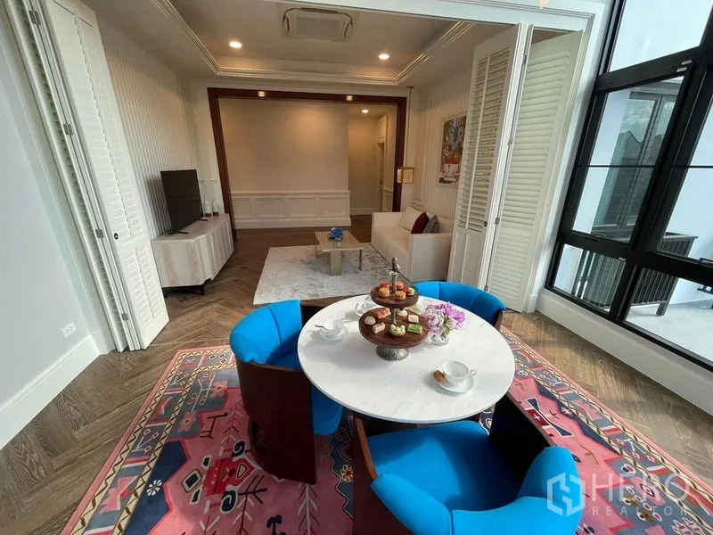 Detached House for rent or sale in Saphan Sung, Bangkok - Bright sunroom and casual dining nook with round table, blue chairs and a pink patterned rug.