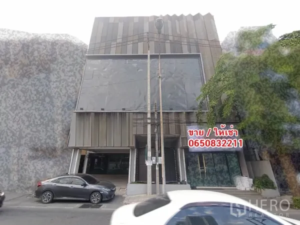 带办公室的家 出租或出售在Phra Khanong, Bangkok - 现代多层家庭办公楼外立面，金属板与玻璃门面，临街可停车，靠近BTS Bang Chak站。