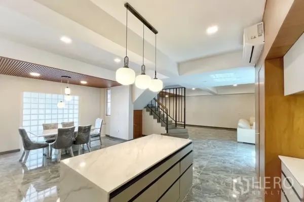 带办公室的家 出租在Watthana, Bangkok - 开放式客厅，石纹地面，带中岛的厨房、吊灯与楼梯。