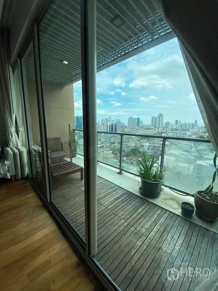 公寓 出租在Yan Nawa, Bangkok - 有遮蔽的木質地板陽台，盆栽點綴，遠眺曼谷天際線。