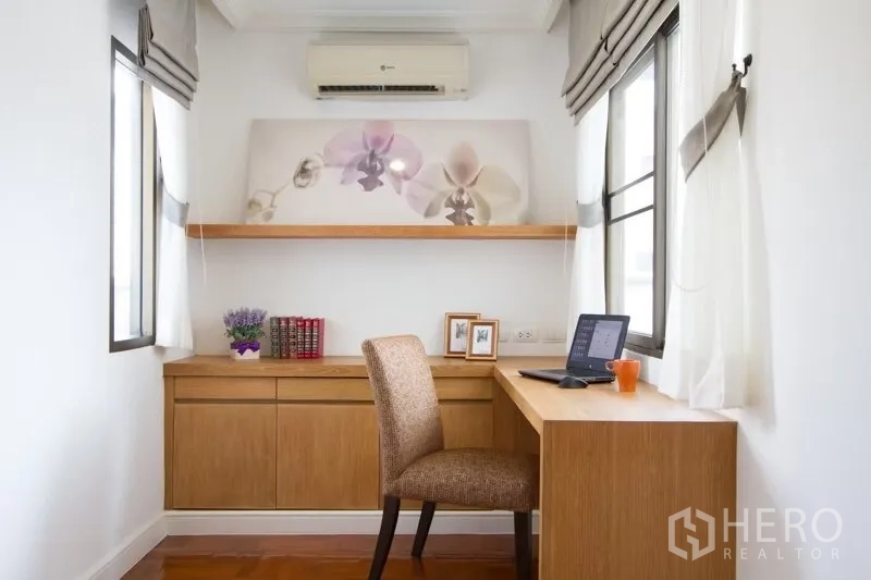 Condominium for rent in Watthana, Bangkok - Bright home office nook with wooden desk, storage cabinets and two windows.