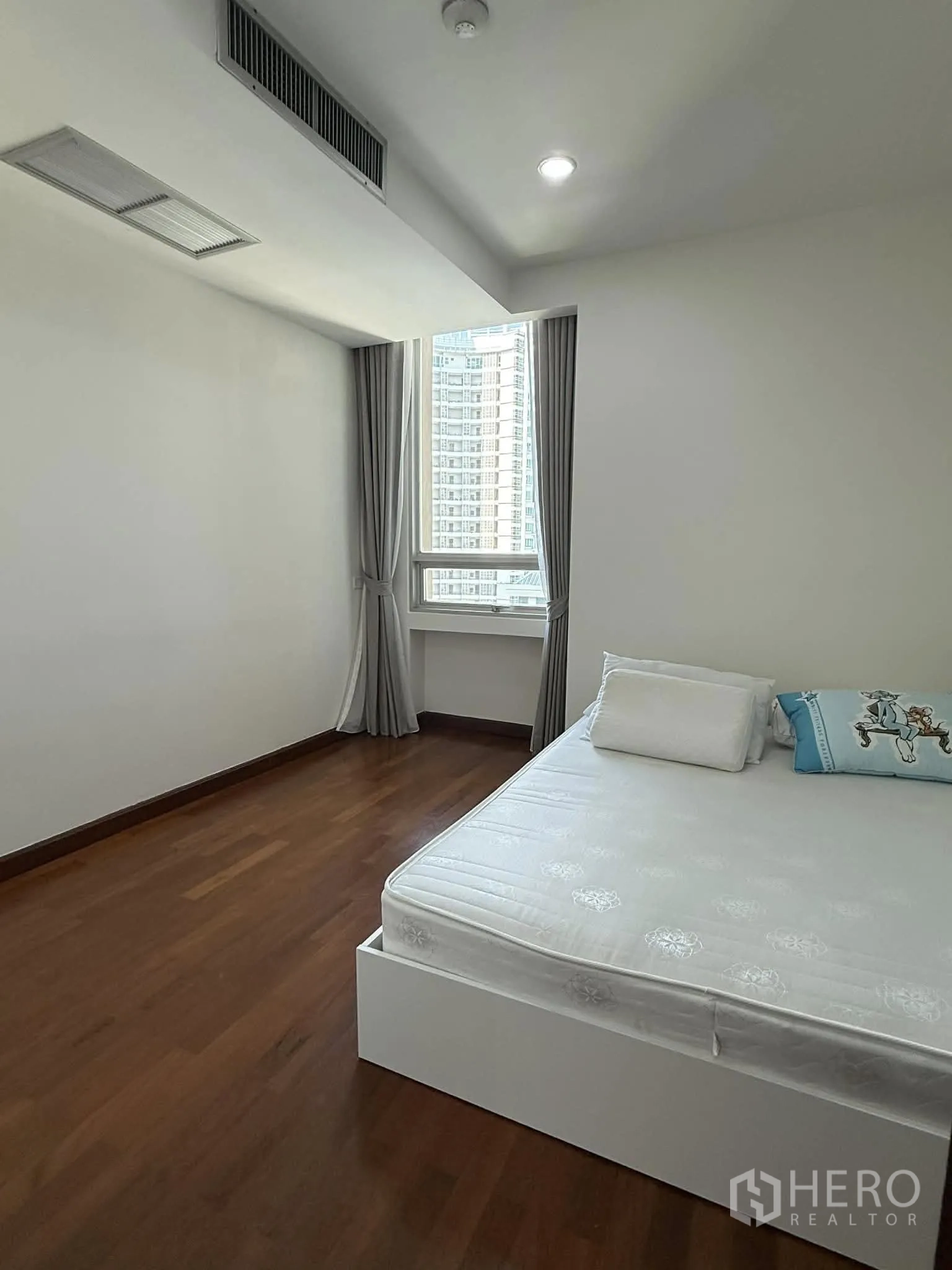 Condominium for rent in Pathum Wan, Bangkok - Bright bedroom with a bed and window overlooking neighboring towers.