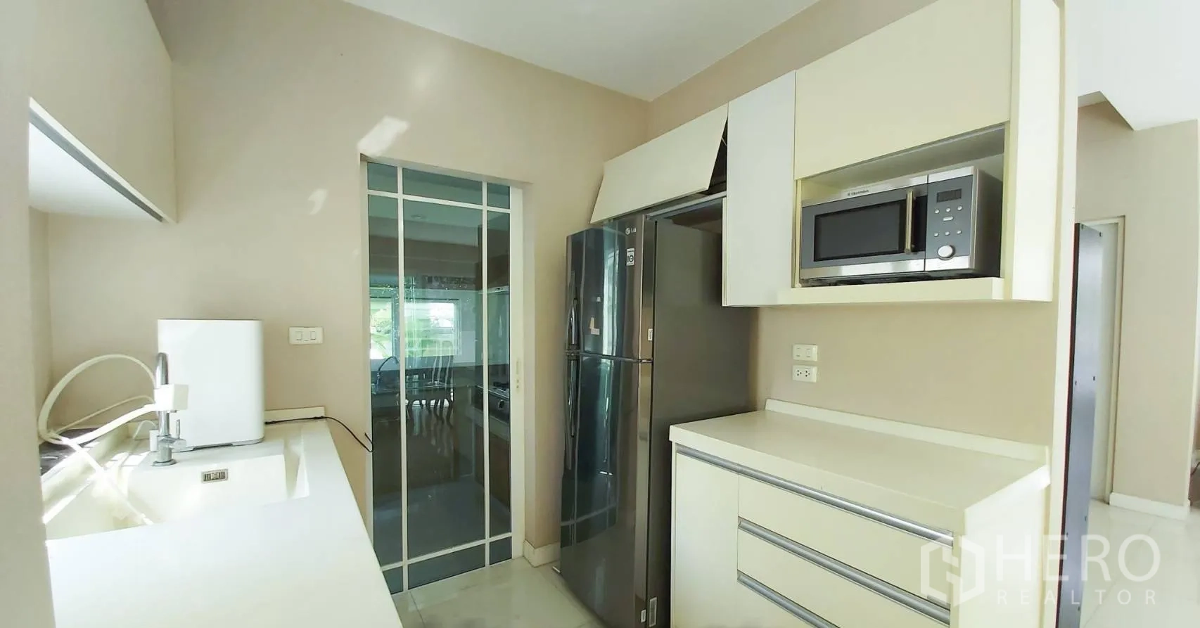 Detached House for sale in Bang Kapi, Bangkok - Modern pantry and fridge in the kitchen with sliding glass to the dining area.