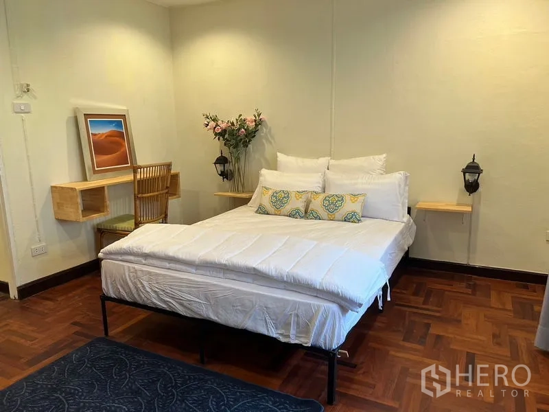 Home Office for rent in Suan Luang, Bangkok - Calm bedroom with double bed, small desk nook and wall lamps.