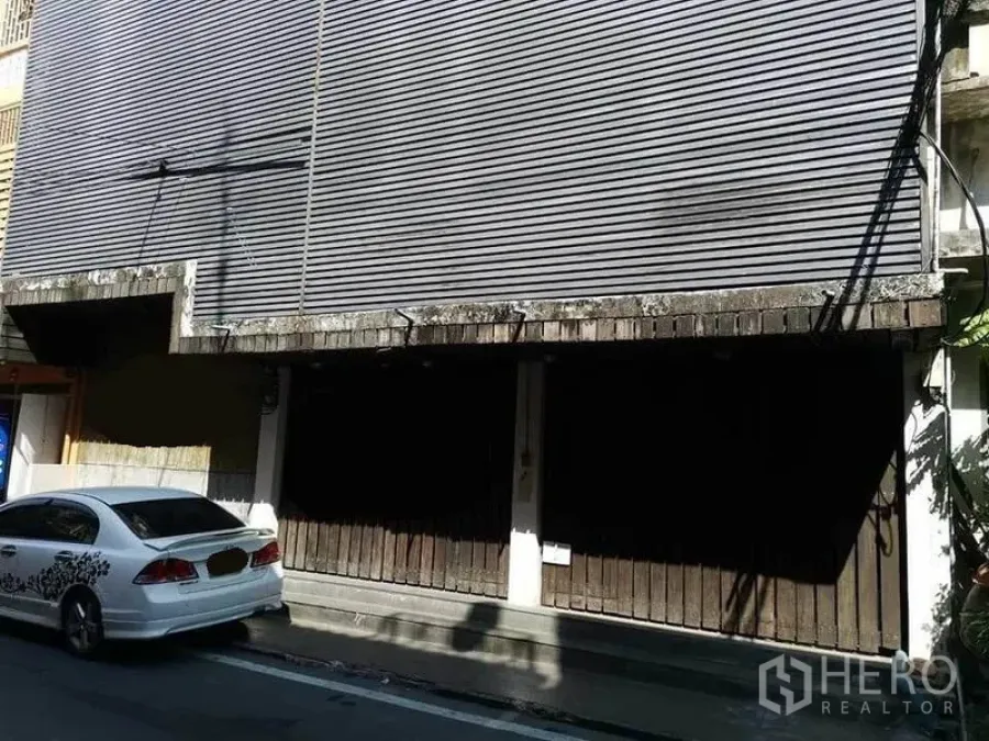 带办公室的家 出租在Khlong Toei, Bangkok - 临街店屋外立面，金属卷帘门与路边停车位.