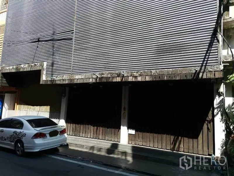 带办公室的家 出租在Khlong Toei, Bangkok - 临街店屋外立面，金属卷帘门与路边停车位.