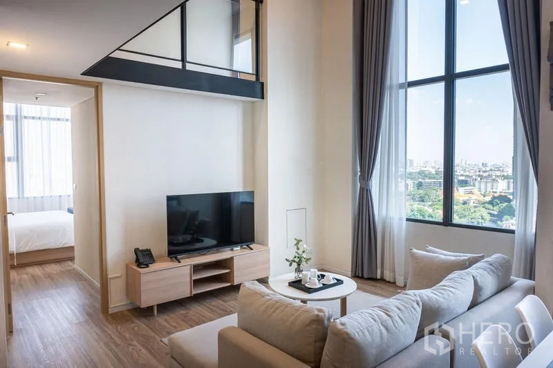 公寓 出租在Khlong Toei, Bangkok - 客厅享城市景观与高窗，左侧通往卧室。
