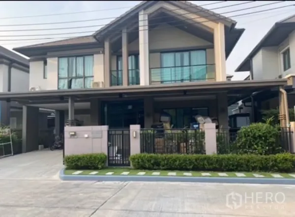 Detached House for rent in Saphan Sung, Bangkok - Modern two-storey detached house with balcony, gated front yard and covered parking in a quiet estate.