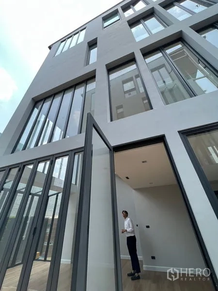 带办公室的家 出售在Wang Thonglang, Bangkok - 曼谷旺通朗现代多层家居办公外立面，落地窗与超高入户门。