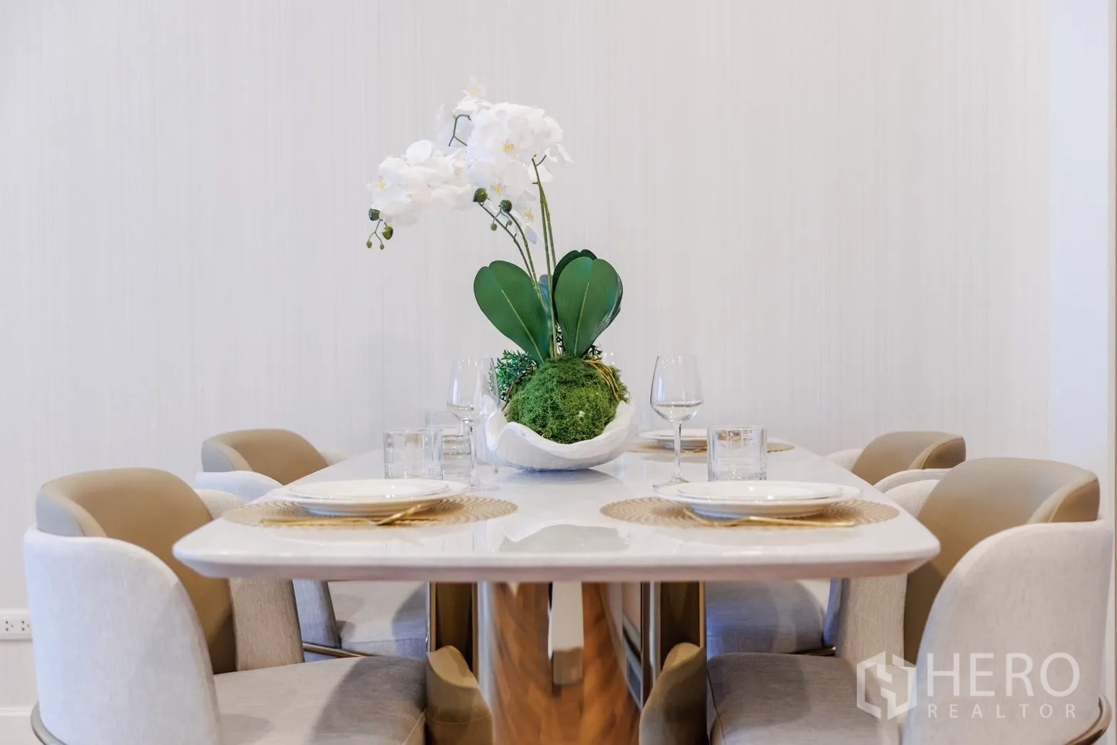 คอนโด for rent or sale in Pathum Wan, Bangkok - โต๊ะรับประทานอาหารสำหรับสี่ที่นั่งตกแต่งด้วยดอกกล้วยไม้