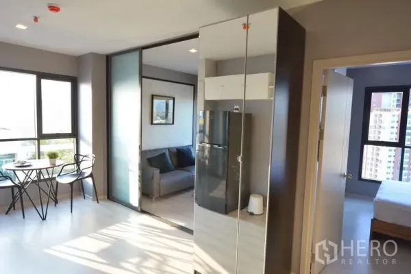 Condominium for sale in Khlong Toei, Bangkok - Sunlit 1-bedroom condo with window dining set, sliding glass partition, and access to the bedroom.