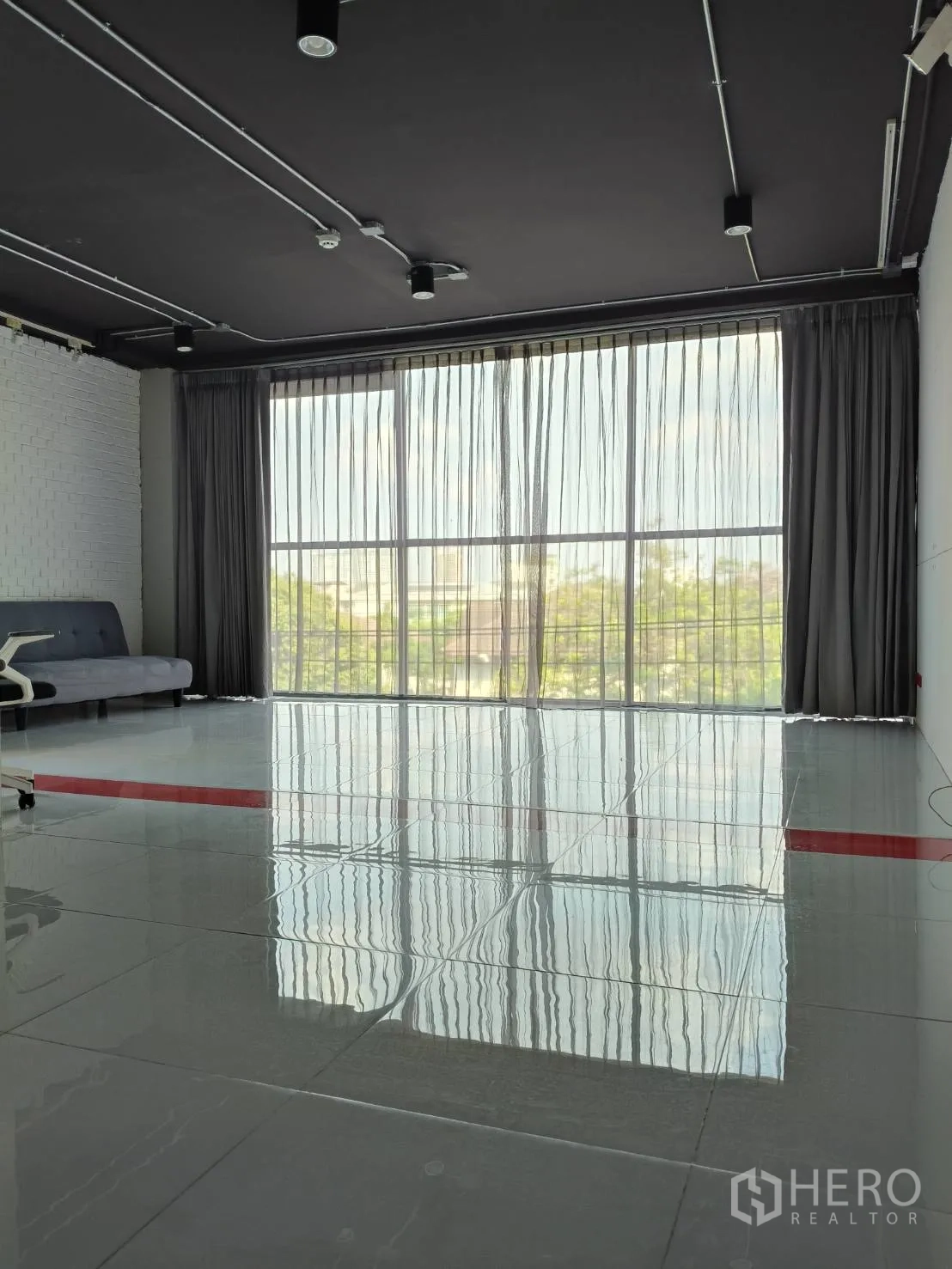 办公空间 出租在Khlong Toei, Bangkok - 采光充足的办公区，落地窗与纱帘，地面高亮反射。