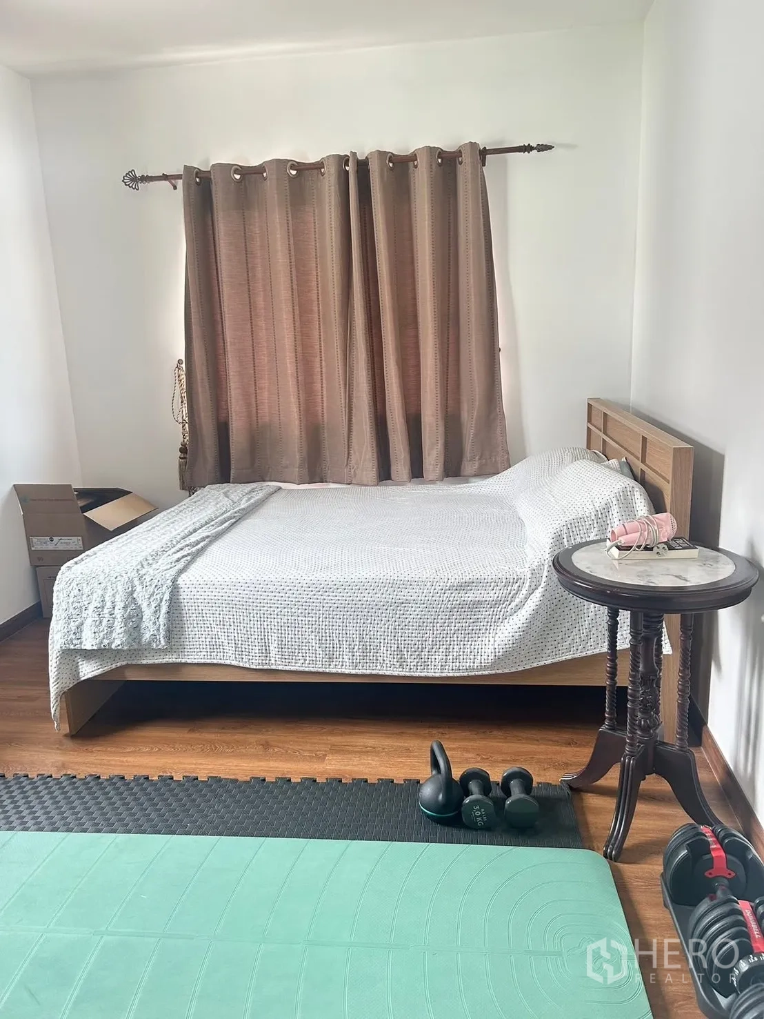 Detached House for rent in Bang Na, Bangkok - Bedroom with wood floor, double bed, bedside table, and exercise mats and weights.