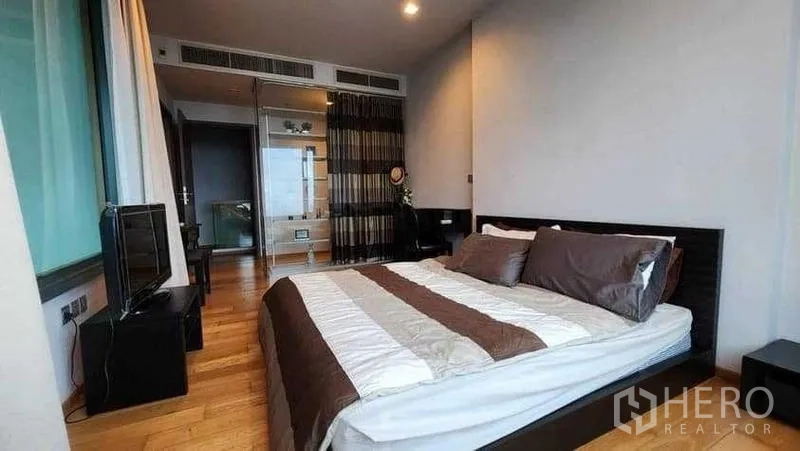 Condominium for rent in Khlong Toei, Bangkok - Master bedroom reverse angle showing bed and wardrobe.
