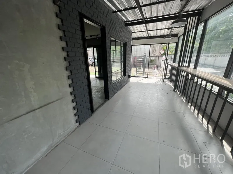Retail Space for rent in Watthana, Bangkok - Enclosed veranda walkway with floor-to-ceiling windows and a metal roof.