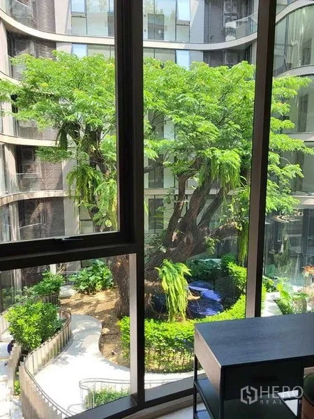 Condominium for rent in Khlong Toei, Bangkok - Window view of lush courtyard with mature tree and walking paths