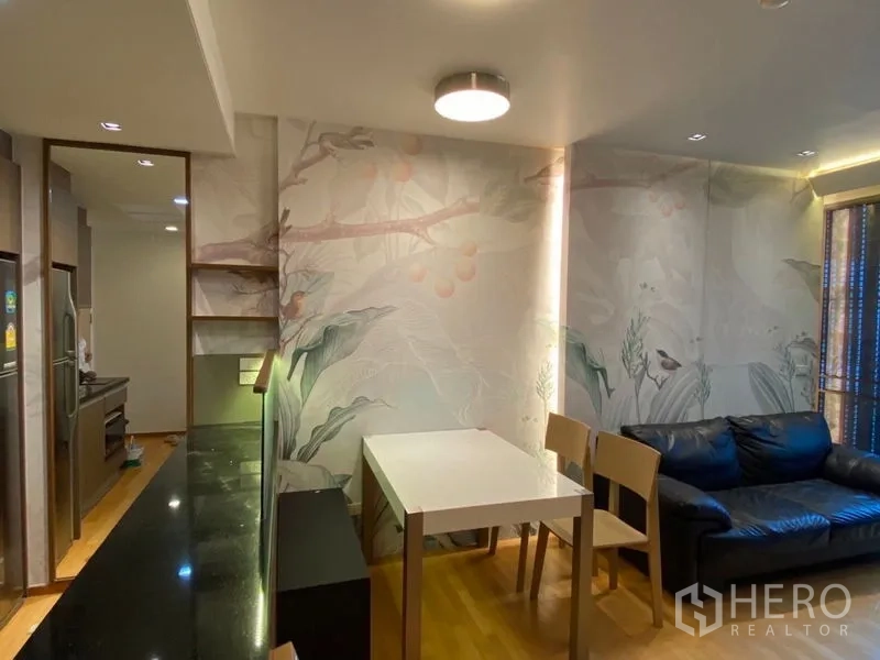 Condominium for sale in Khlong Toei, Bangkok - Open-plan living and dining area with sofa, dining table and kitchen pass-through.