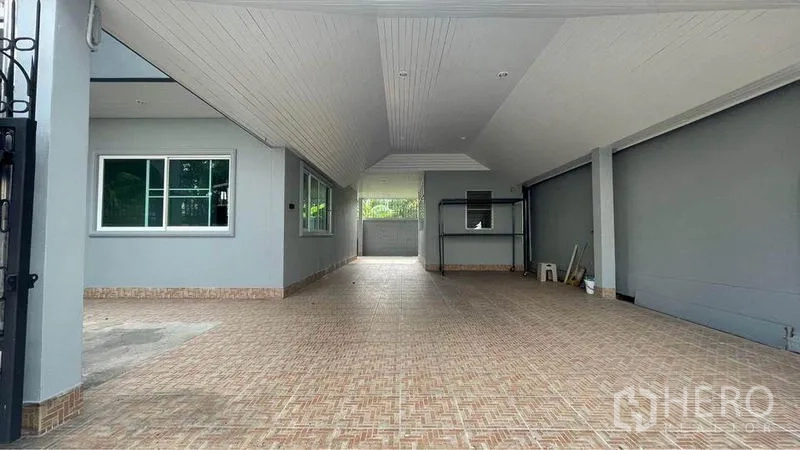 Detached House for rent in Bang Kapi, Bangkok - Wide covered carport with high ceiling and patterned floor tiles for multiple cars.