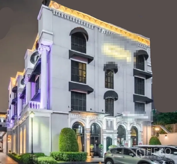 零售空间 出租在Huai Khwang, Bangkok - 夜景下的新古典商业建筑，拱形窗与立面灯光，可停放车辆，位于曼谷Huai Khwang。