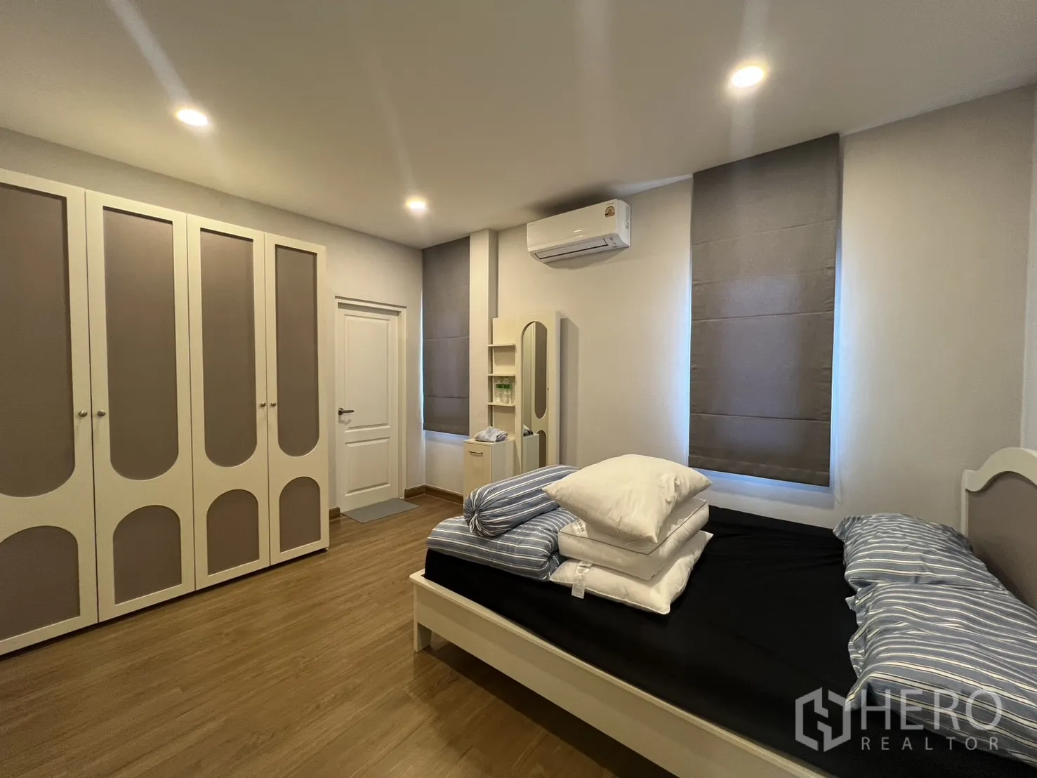 独栋房屋 for rent in Lat Krabang, Bangkok - 卧室整面衣柜与床，嵌灯与木地板。