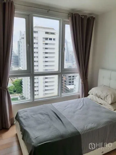 คอนโด ให้เช่าในWatthana, Bangkok - ห้องนอนสว่างพร้อมหน้าต่างบานใหญ่ ผ้าม่าน และวิวสกายไลน์ในคอนโดย่านวัฒนา