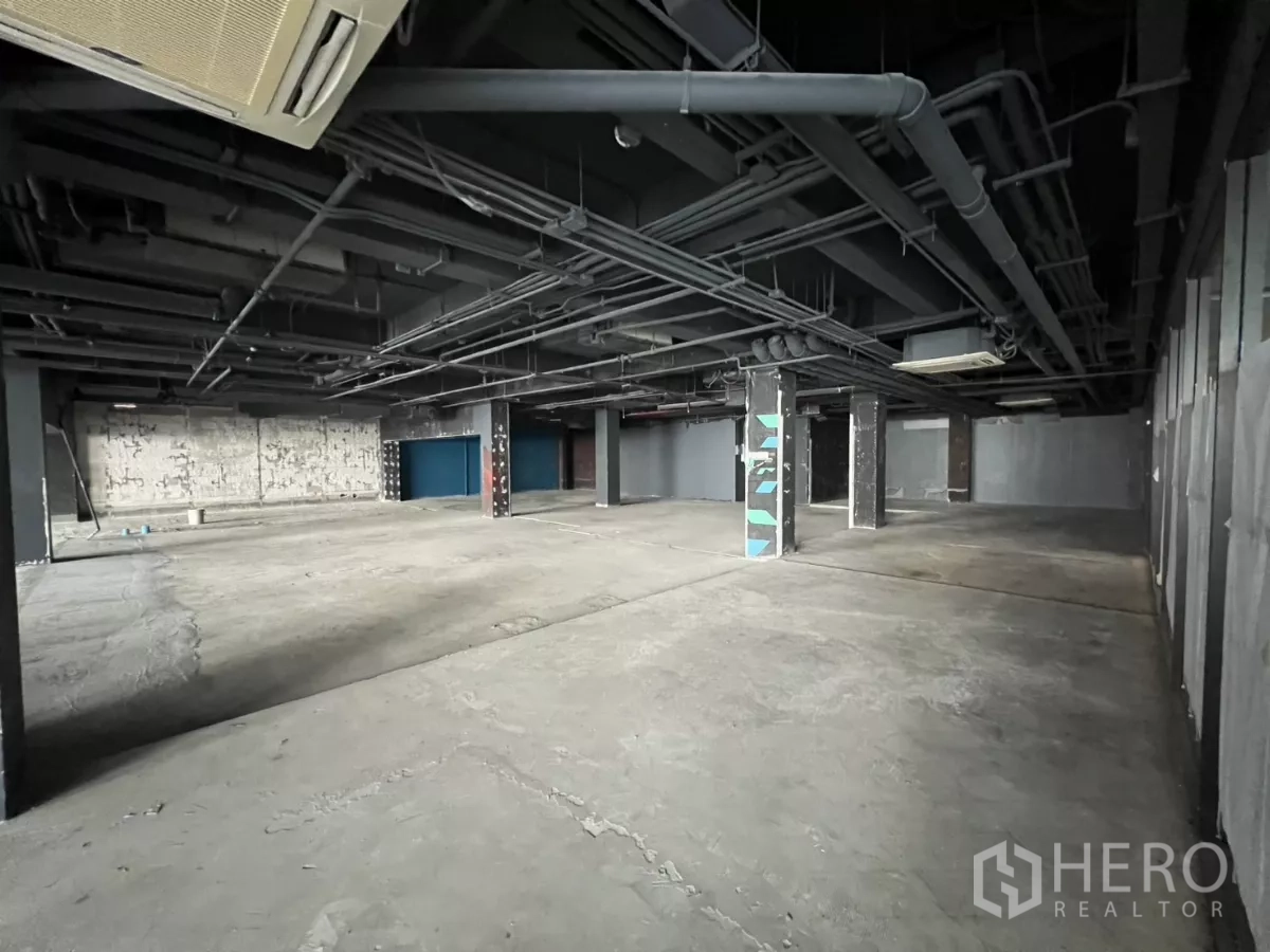 Retail Space for rent in Watthana, Bangkok - Unfurnished retail hall with columns and visible piping overhead