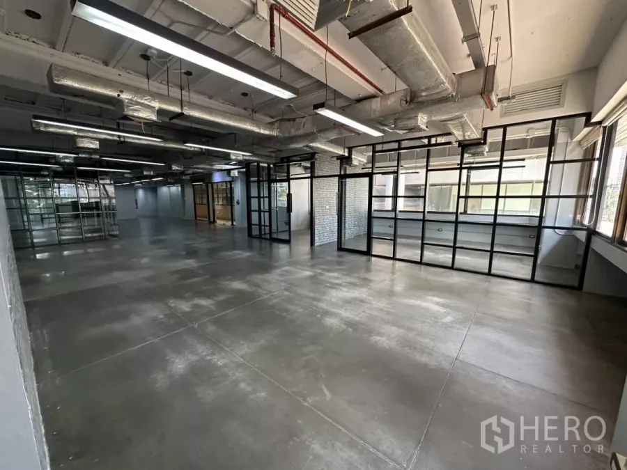 办公空间 出租 - 宽敞工作区，落地网格玻璃墙与线性LED照明。